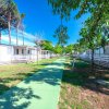 Sentiero verde tra case mobili bianche, circondato da alberi.