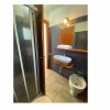Bagno con doccia, lavabo e bidet su piastrelle beige.