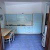 Cucina moderna con mobili azzurri e tavolo.