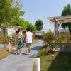 Coppia cammina su un vialetto circondato da giardini e bungalow.