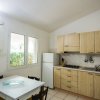 Cucina luminosa con tavolo e frigorifero.
