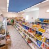 Negozio alimentare con scaffali pieni di prodotti.