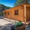 Bungalow di legno con veranda tra gli alberi.