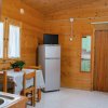 Interno in legno con tavolo apparecchiato e frigorifero.