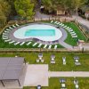 Piscina a forma di fagiolo con lettini intorno.
