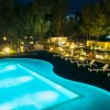 Piscina illuminata di notte, circondata da lettini.