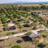 File di bungalow tra alberi su sentieri sterrati.