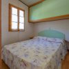 Camera con letto matrimoniale e copriletto floreale.
