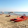 Spiaggia con barca di salvataggio e ombrelloni.