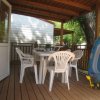 Veranda in legno con tavolo bianco e canotto.