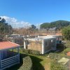 Diverse casette con giardino ed alberi spogli sotto un cielo sereno.