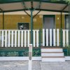 Casa mobile con veranda, recinzione bianca e gradini.