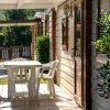 Tavolo e sedie bianche su una veranda con giardino.