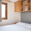 Camera con letto matrimoniale, finestra, armadio a muro e mensole.