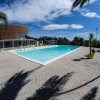 Una piscina all'aperto con area pavimentata e palme intorno.