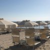 Ombrelloni e lettini sulla spiaggia, con mare calmo sullo sfondo.
