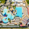 Vista aerea di piscine e lettini con ombrelloni.