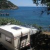 Roulotte parcheggiata vicino al mare con vista panoramica.