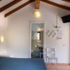 Camera con soffitto a travi, letto e bagno in fondo.