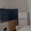 Cucina compatta con frigo e lavatrice.