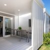 Veranda con tavolo, sedie e giardino.