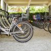Fila di biciclette con seggiolini per bambini in un'area coperta.