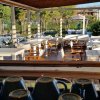 Area bar con tavoli bianchi vicino a una piscina.