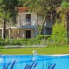 Piscina con giardino e casa sullo sfondo.