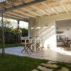 Veranda con tavolo e sedie vicino a un giardino.