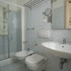 Bagno con doccia in vetro, lavabo, wc e bidet. Pavimento e pareti con piastrelle chiare.
