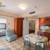 Interno di un appartamento con soggiorno, cucina, tavolo apparecchiato e camera da letto.