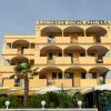 Edificio del Residence Costa Azzurra, giallo con balconi e piante davanti.