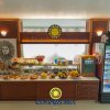 Buffet con cibi assortiti e bevande, decorato con insegna 