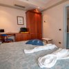 Camera d'albergo con letto matrimoniale e scrivania in legno.