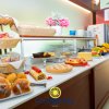 Un buffet con dolci assortiti su un tavolo, decorato con cestini e fiori rosa.