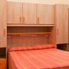 Camera con letto matrimoniale e armadio in legno.