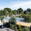 Piscina all'aperto circondata da alberi e strutture, vista dall'alto.
