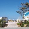 Ingresso del Villaggio Turistico La Capannina con cartello e vista sul mare.