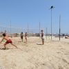 Persone che giocano a beach volley su una spiaggia sabbiosa.