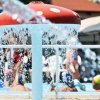 Una piscina con un fungo gigante da cui scorre acqua, persone nuotano intorno.