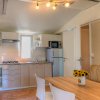 Cucina moderna con tavolo, sedie bianche e un vaso di girasoli.