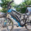 Due mountain bike elettriche nere e blu parcheggiate su un vialetto.