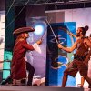 Due attori in costume da pirati si sfidano con spade su un palcoscenico.