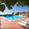 Piscina all'aperto con sdraio e ombrelloni gialli.