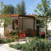 Bungalow in legno con piccolo giardino fiorito e veranda.