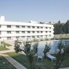 Edificio bianco con piscina e lettini.