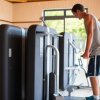 Uomo utilizza attrezzi in una palestra luminosa.