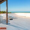 Terrazza con tavolo, sedie e sdraio, vista panoramica sul mare.