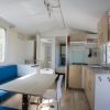 Interno di una casa mobile con cucina, tavolo da pranzo e divano blu.