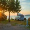 Camper al tramonto vicino a un lago.